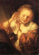 REMBRANDT Harmenszoon van Rijn Young Woman Trying on Earrings china oil painting artist